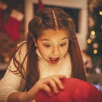 happy young girl opening holiday gift