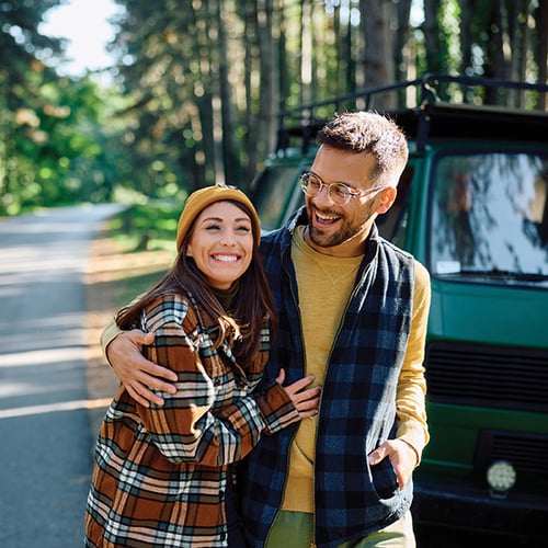 hapy couple standing next to car