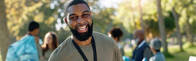 Man, volunteer and happy portrait with clipboard in nature, supervisor and environment sustainability project with group