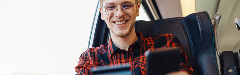 Passenger is using credit card and phone in train for online shopping.