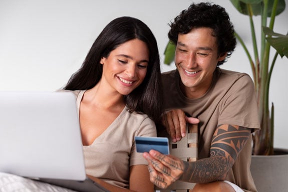 Young-couple-practicing-healthy-credit-card-habits-while-paying-their-credit-card-bill-on-their-laptop.