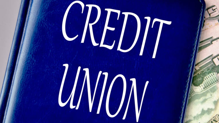 CREDIT UNION - words on a blue book on a gray background with banknotes