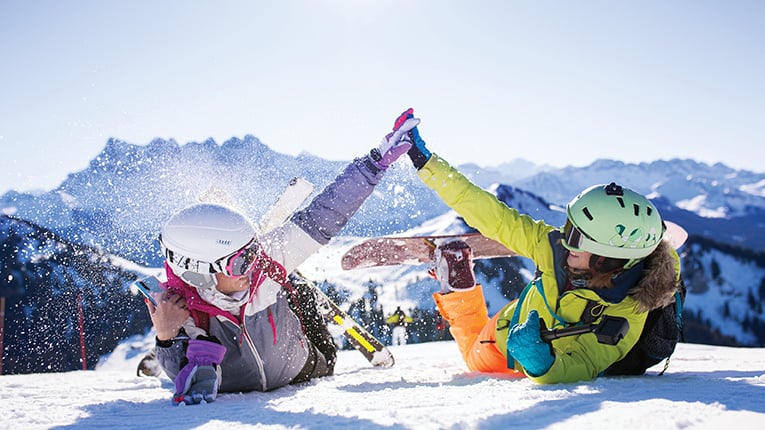 Two girls with ski and snowboard having fun on snow