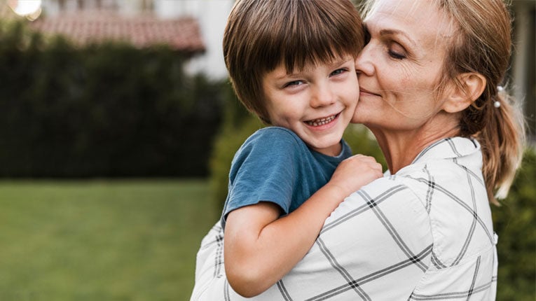 An adjustable rate mortgage is helping this grandmother save money while helping her grandson that she is holding in her arms.